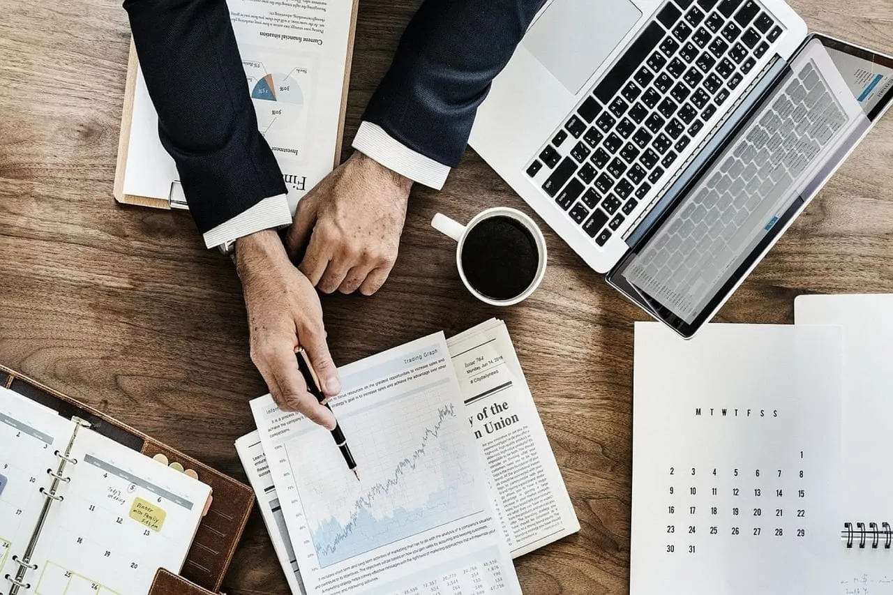 Photo showing businessman, laptop, stocks and stock exchange.