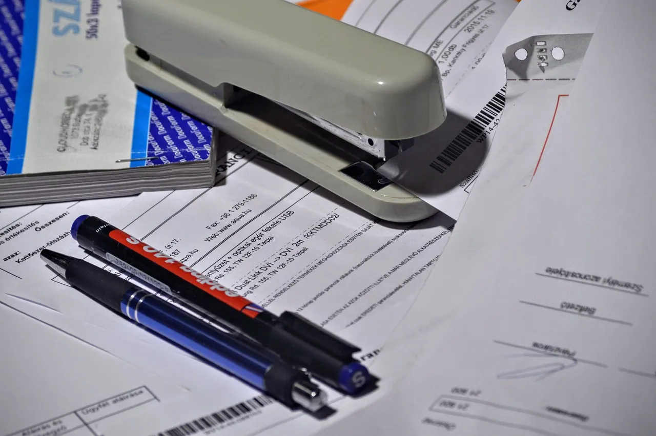 Photo showing stapler, pen and paperwork.