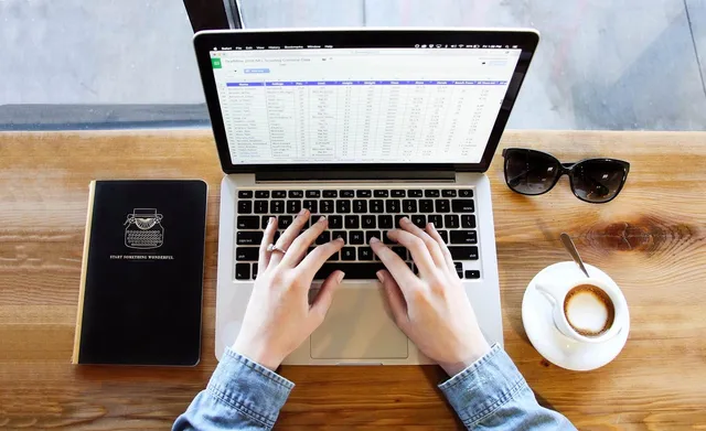 Photo showing notebook, typing and coffee.
