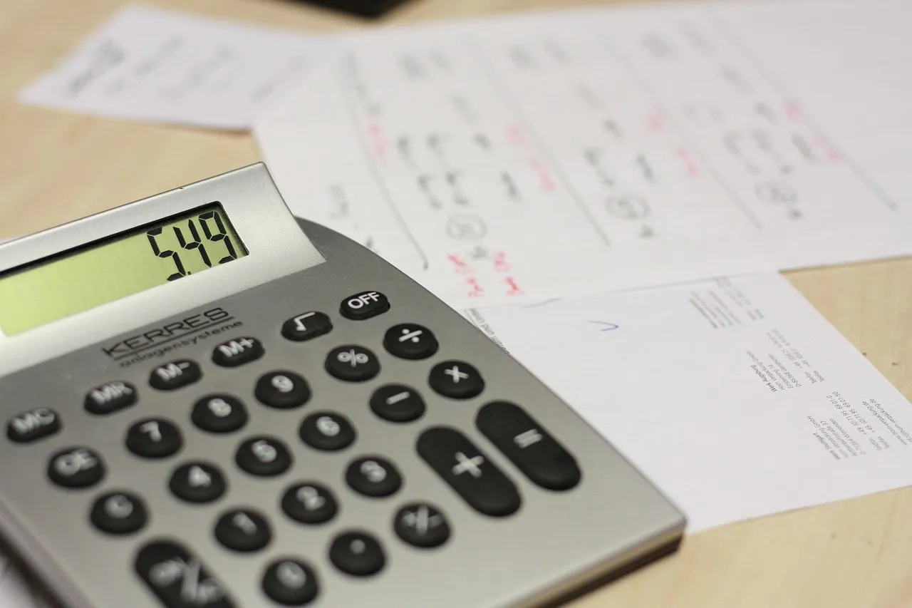 Photo showing calculator, table and invoice.
