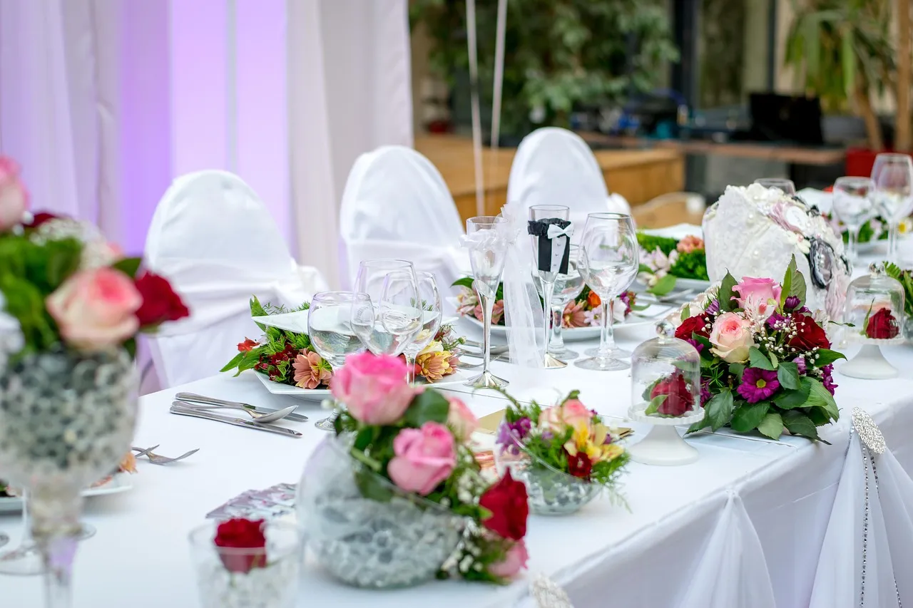 Photo showing wedding reception, table setting, flowers and nature.
