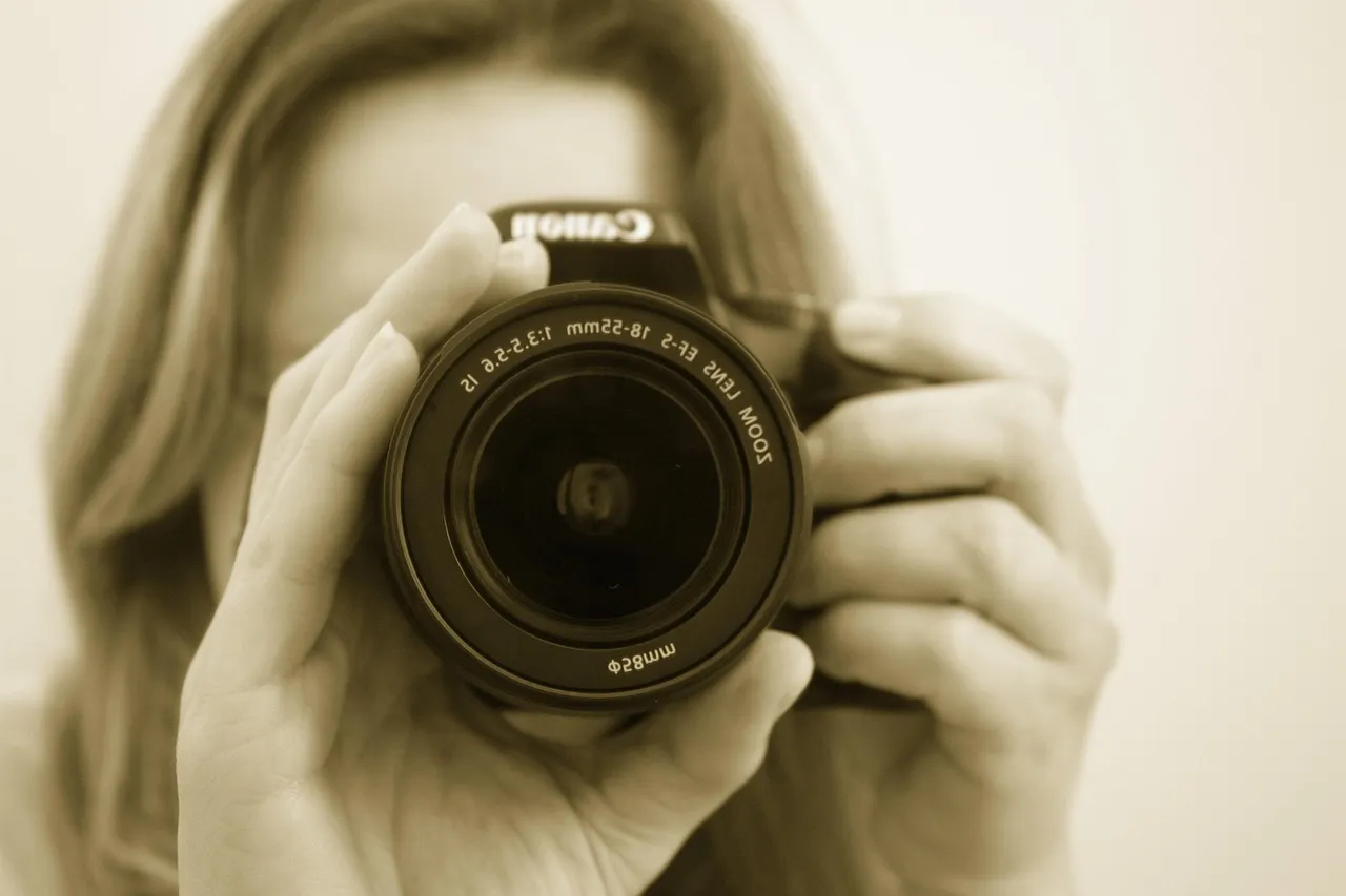 Photo showing photographer, camera, lens and female.