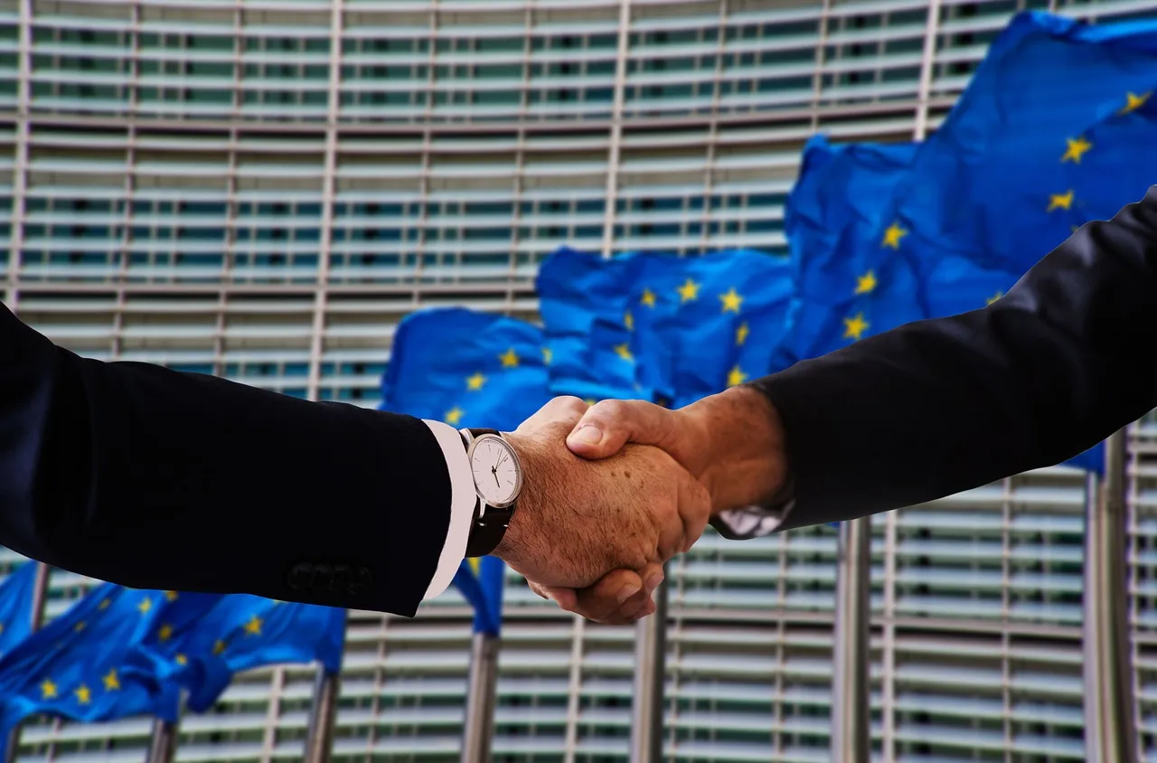Photo showing handshake, shaking hands, europe and flag.