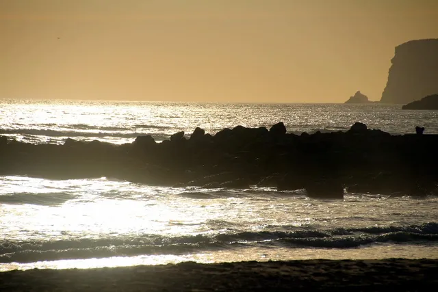 Photo showing beach, rocks in the sea and sea.