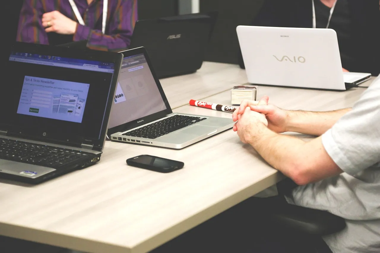 Photo showing laptops, meeting, businessmen and coworkers.