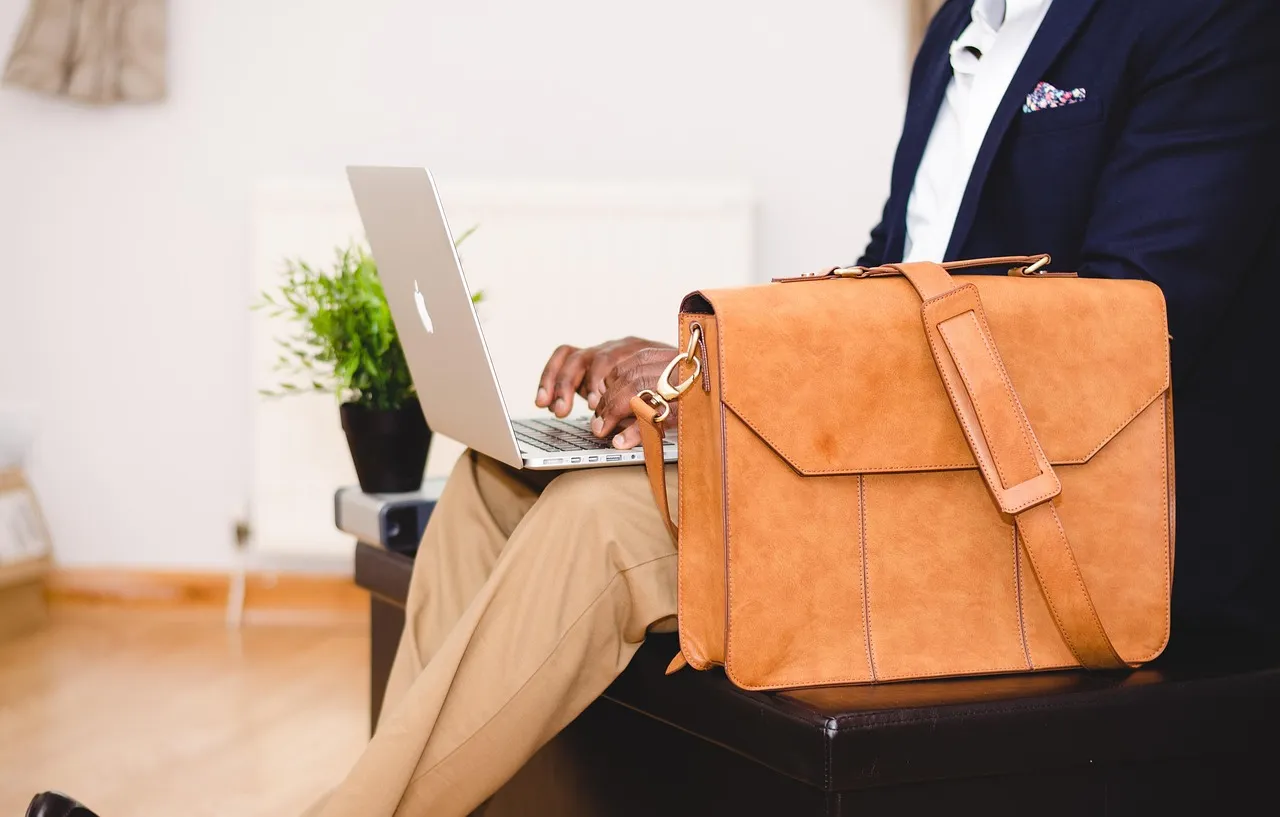 Photo showing businessman, laptop, bag and chair.
