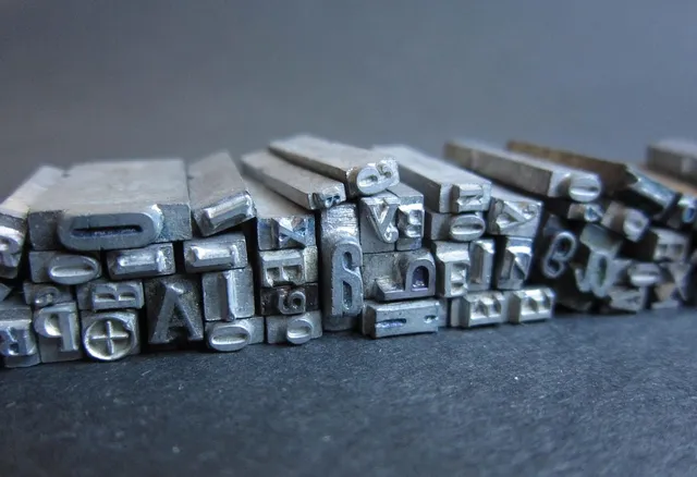 Photo showing letters, printing press and metal letters.