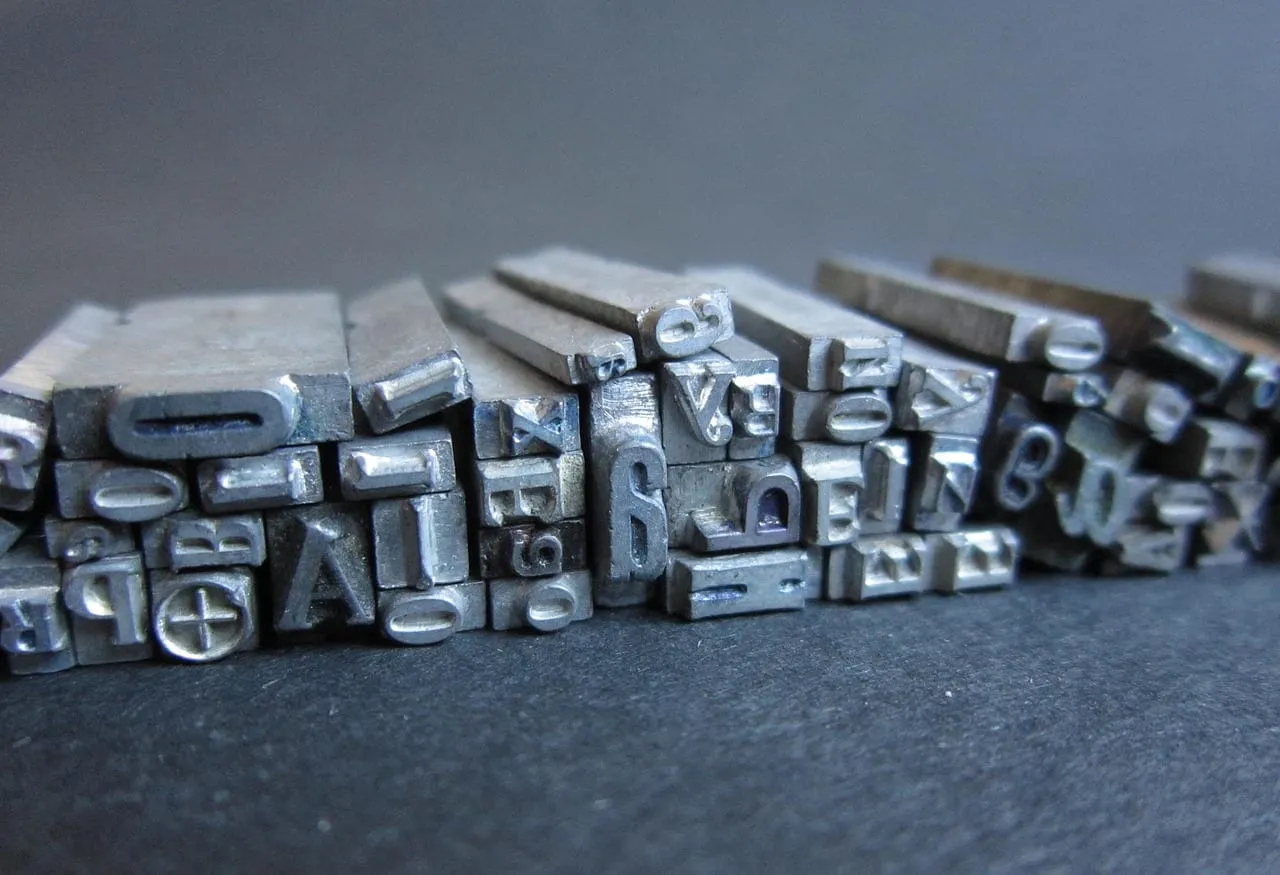 Photo showing letters, printing press and metal letters.