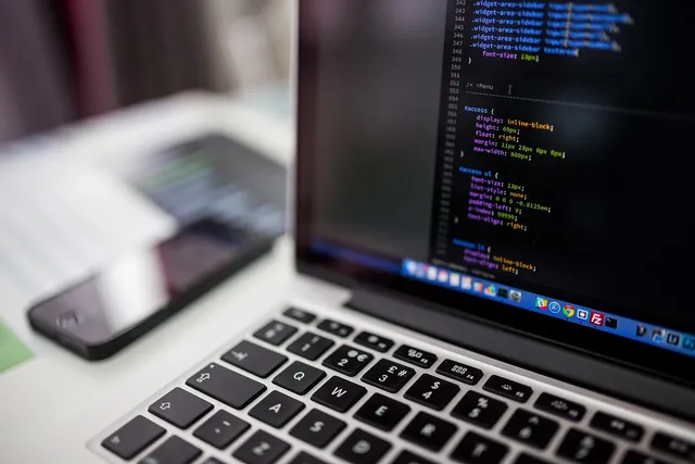 Photo showing laptop, macbook and codes.