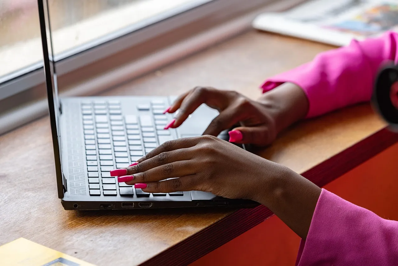 Photo showing laptop, typing and working.