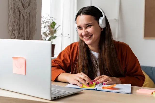 Photo showing woman, headphones and notebook.